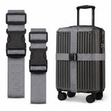 Gunmetal luggage straps in two lengths beside hardshell suitcase, buckle detail