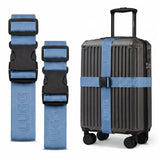 Slate Blue luggage straps in two lengths beside hardshell suitcase, buckle detail