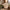 Stone luggage tag on cream cabin suitcase handle in hotel bedroom