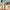 Woman walking a Cream & Brown large hard shell suitcase along a seaside promenade